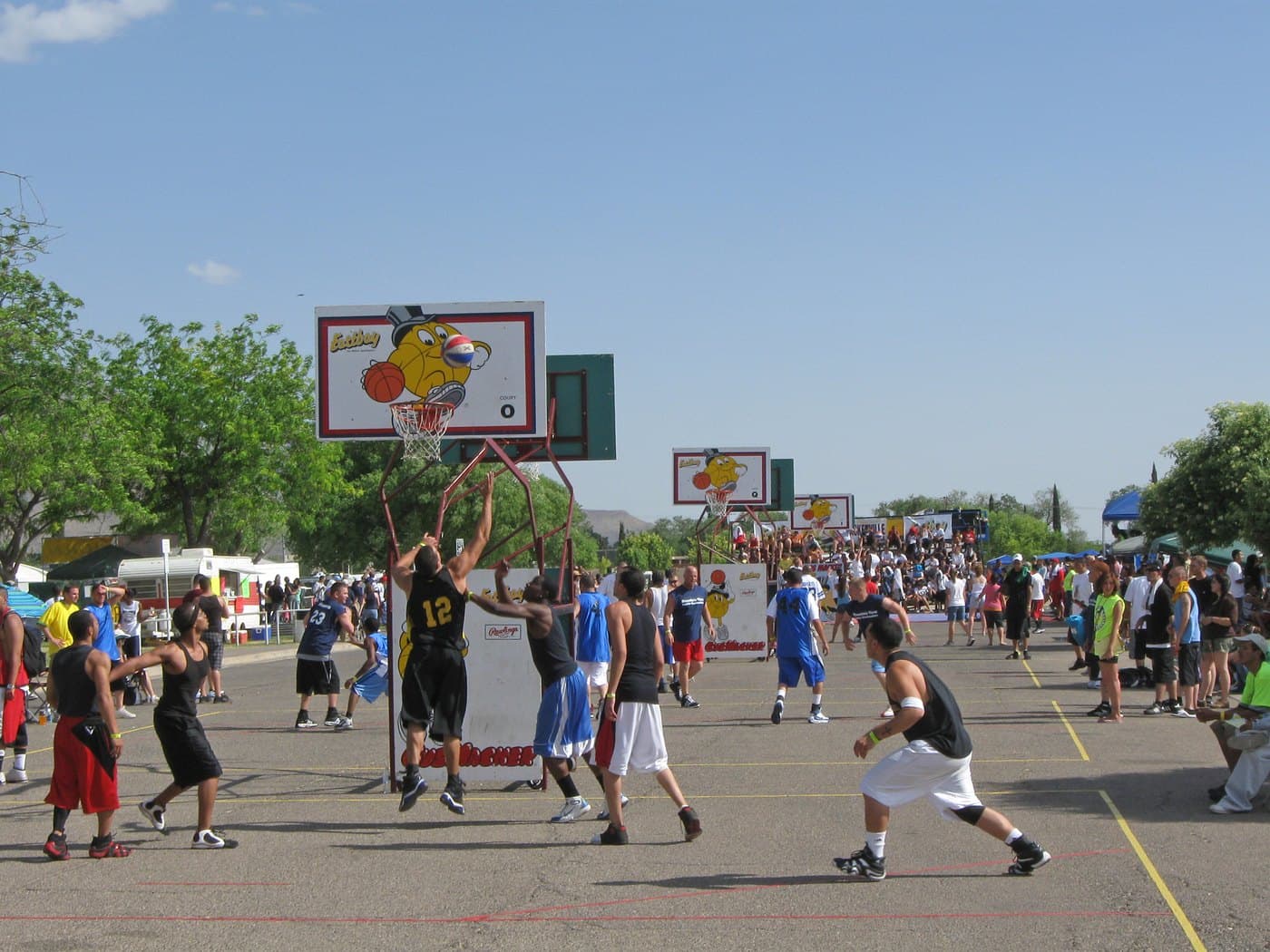 People playing street basketball at an outdoor community tournament